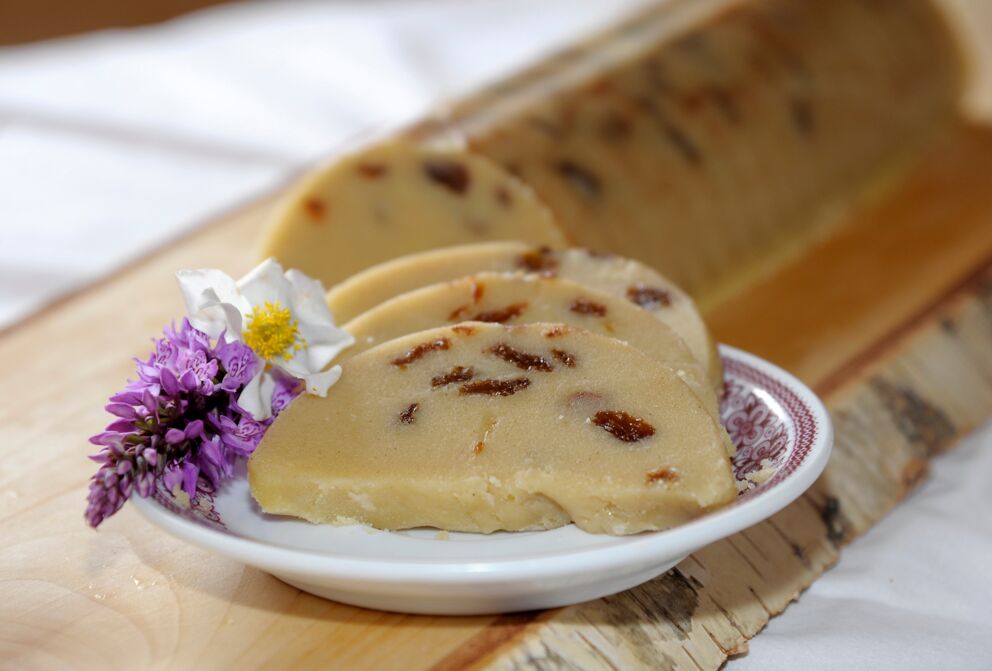 Slices of traditional Lungauer Reindling garnished with flowers on a wooden board.