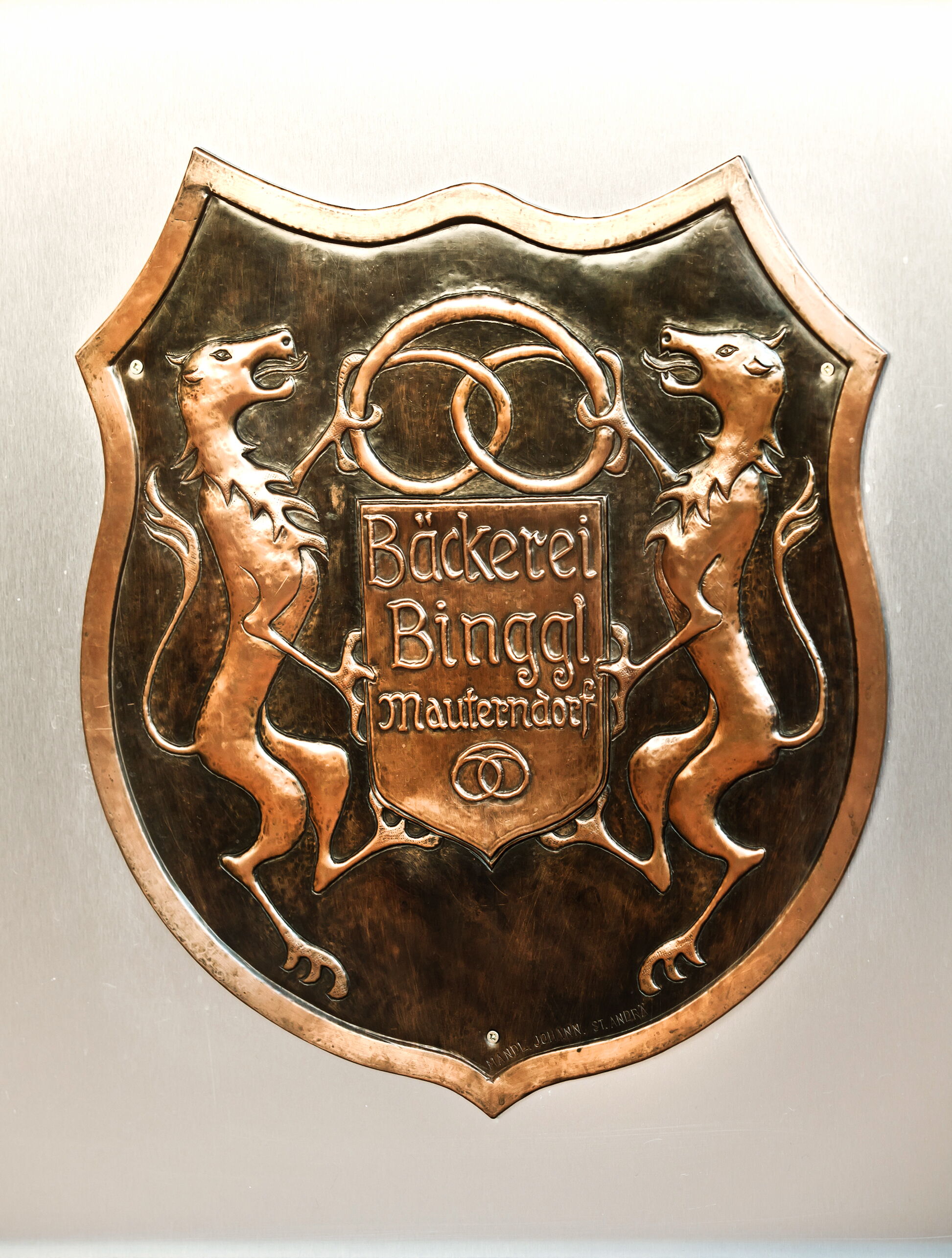 Historisches Emblem der Bäckerei Binggl in Mauterndorf, kunstvoll in Metall gestaltet.