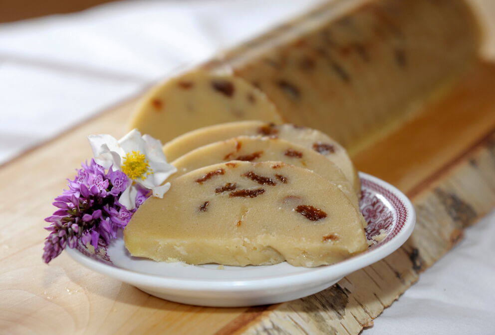 Slices of traditional Lungauer Reindling garnished with flowers on a wooden board.
