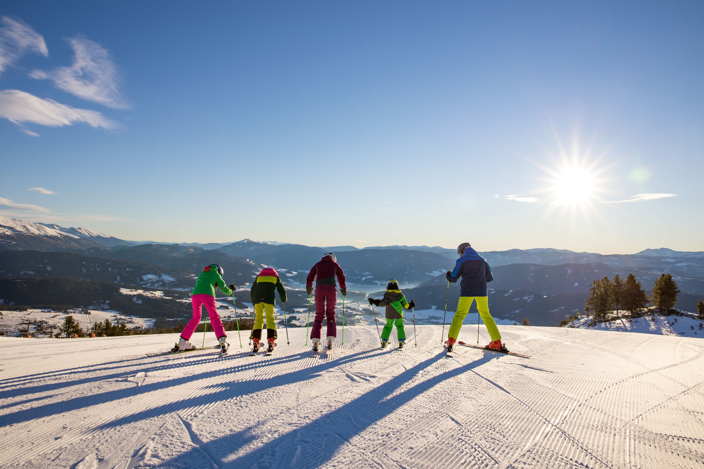 Familie auf Skiern genießt sonnigen Wintersporttag in den Alpen.