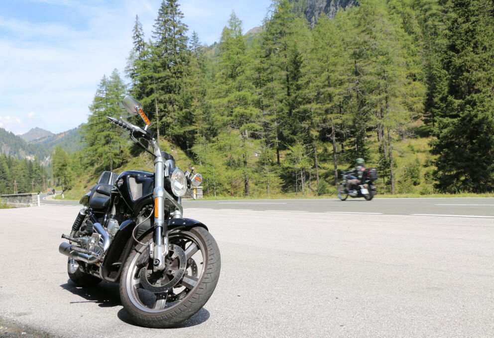 Motorrad auf einem Rastplatz in Österreich, umringt von Bäumen