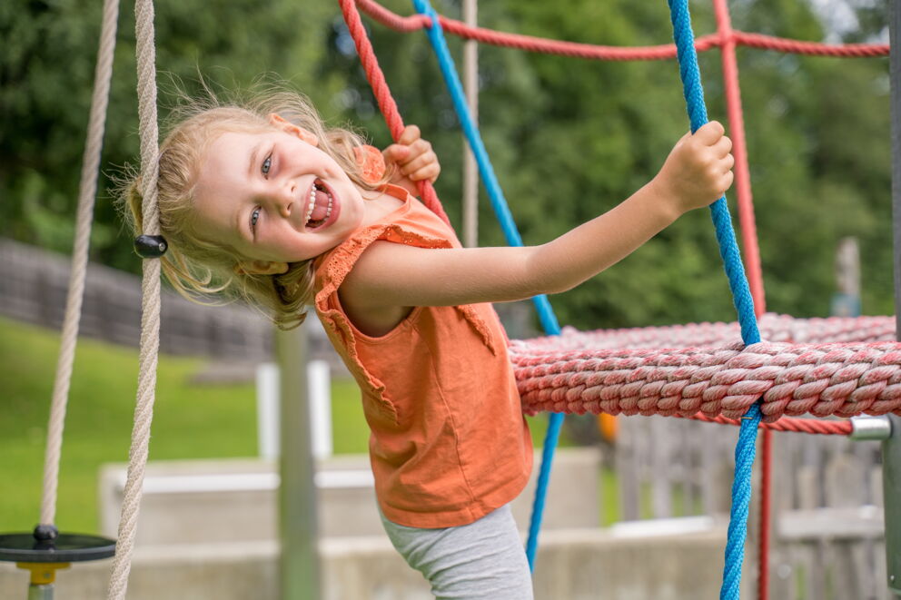 Mädchen genießt die Zeit auf dem Spielplatz in den Sommerferien in Mauterndorf, Lungau, Salzburg Land
