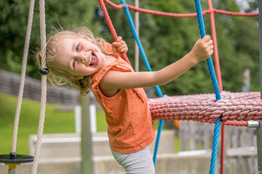 Mädchen genießt die Zeit auf dem Spielplatz in den Sommerferien in Mauterndorf, Lungau, Salzburg Land