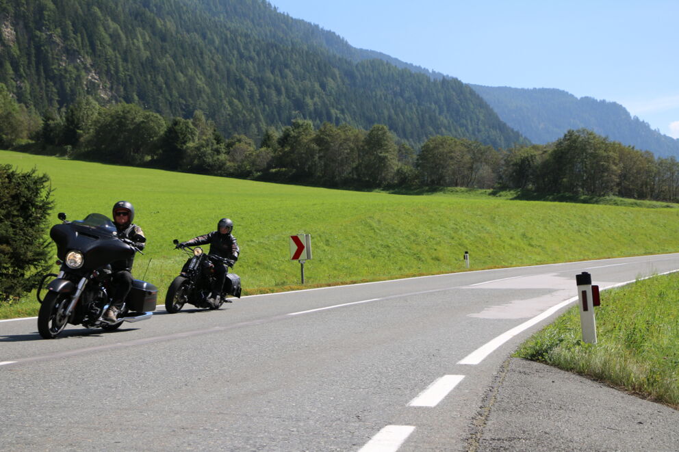 Zwei Motorradfahrer auf einer Landstraße im Sommer in Österreich